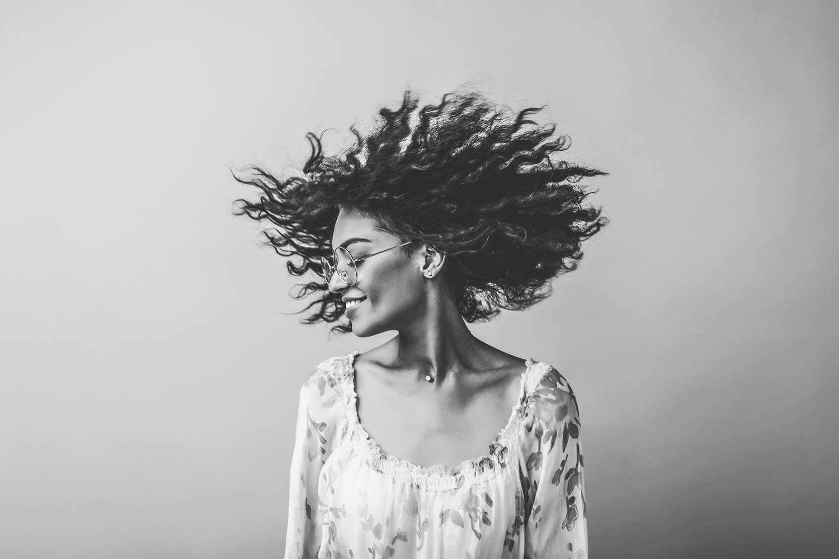 Portrait of a woman, hair blowing through the wind. Black and white preset.
