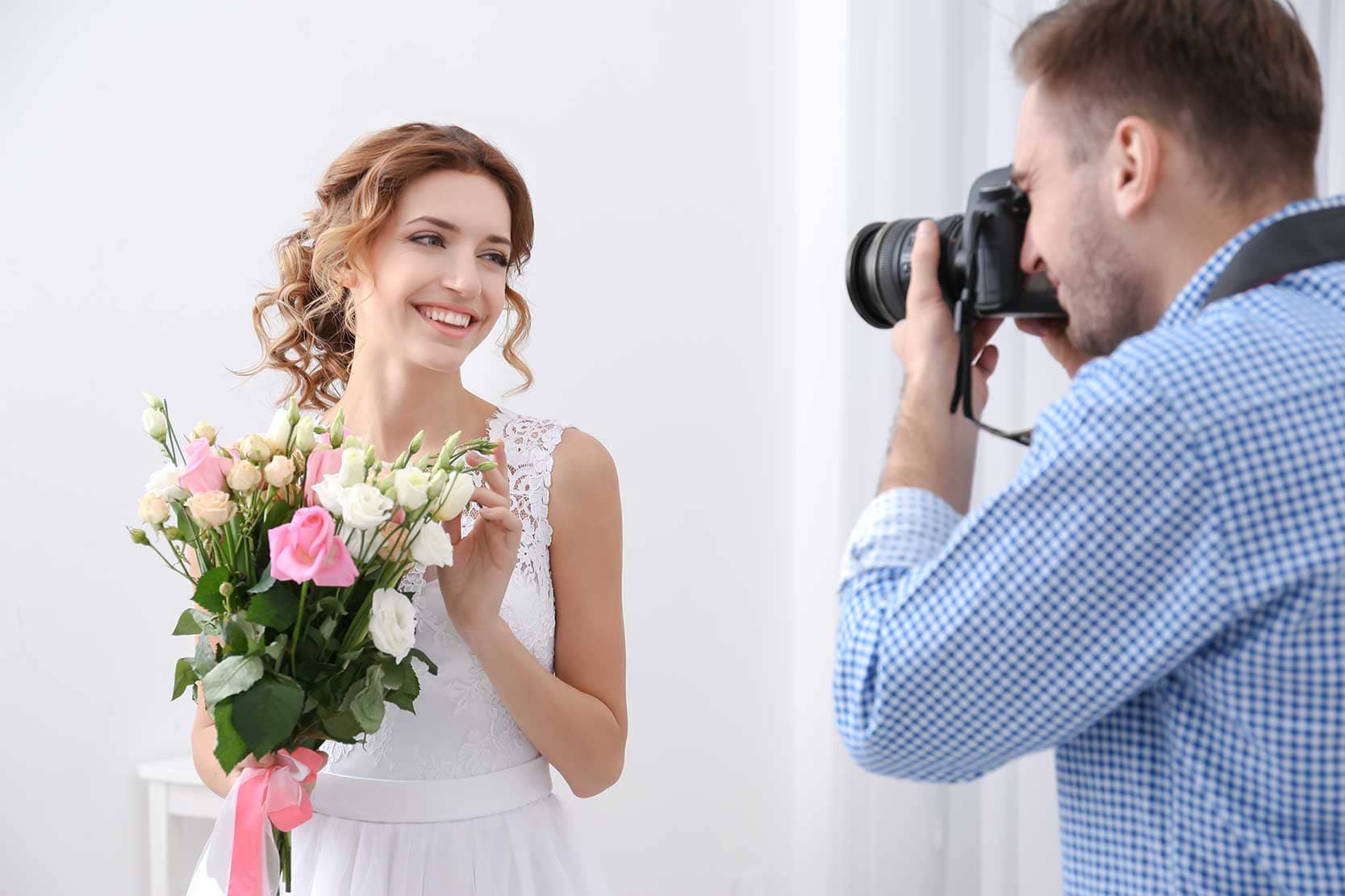 A wedding photographer taking a photo of a bride